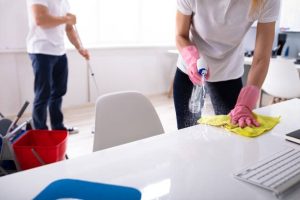 Facilities management cleaners spot cleaning a table